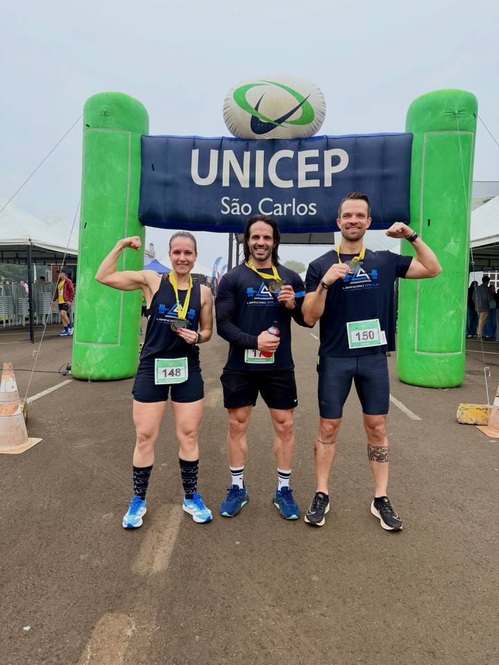 Leandro e alunos com medalhas na chegada de uma corrida de rua em São Carlos