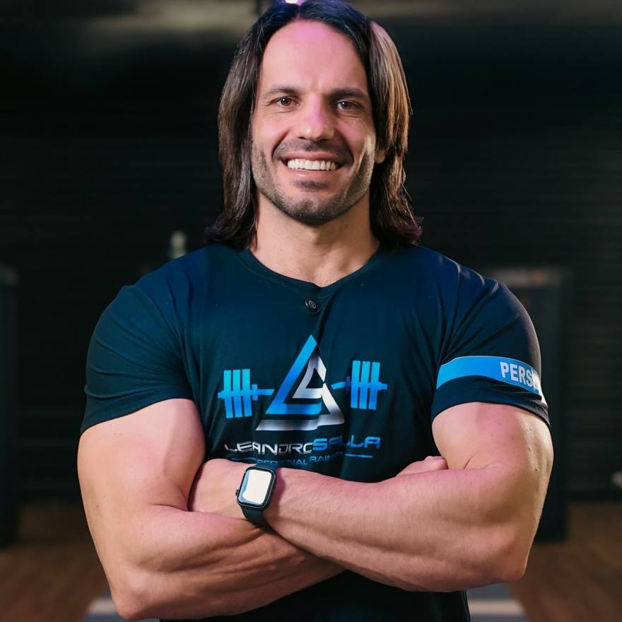 Leandro Salla, personal trainer em São Carlos, sorrindo de braços cruzados com a camiseta da sua marca